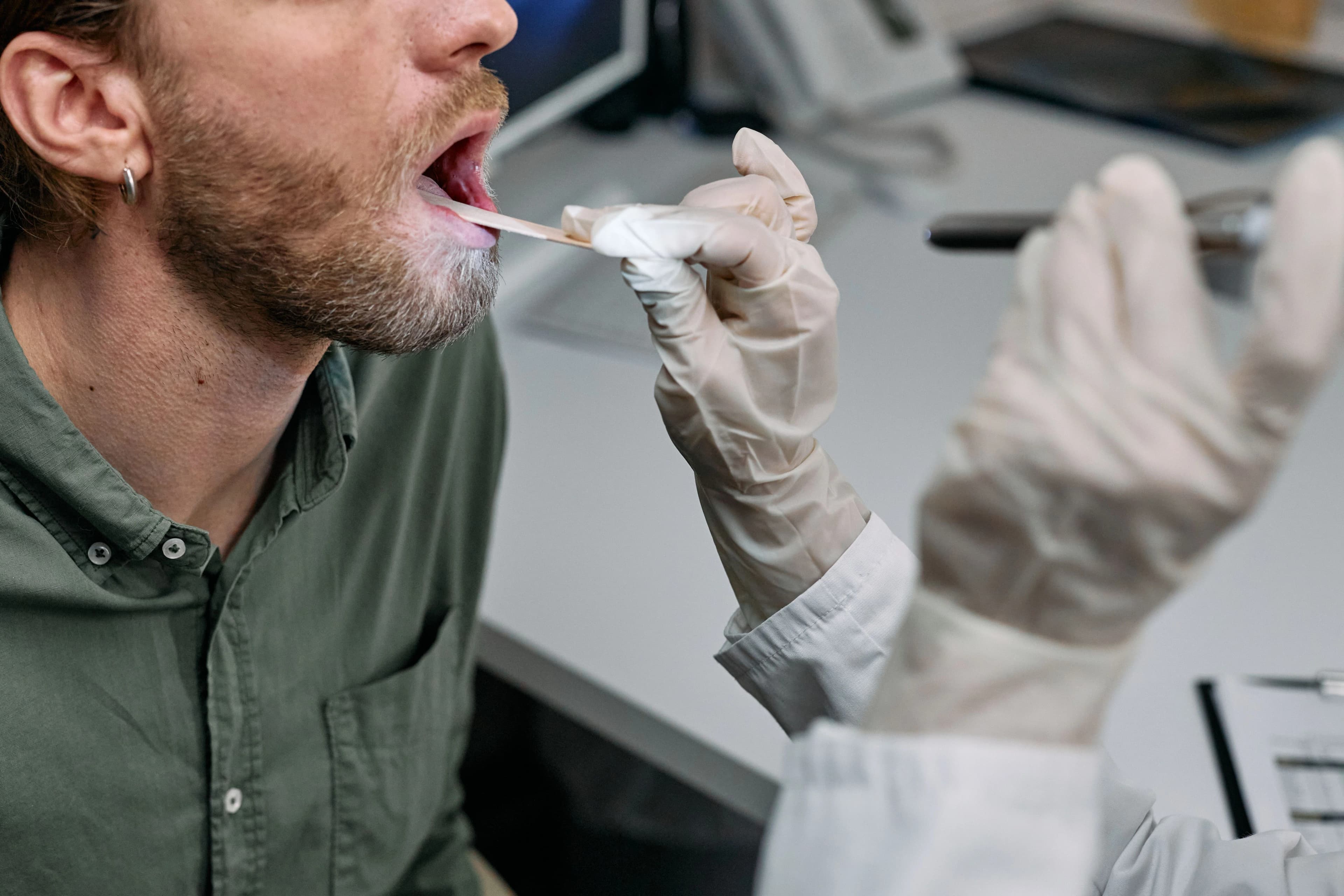 Photo patient receiving oral cancer screening in Astoria NY with mouth swab