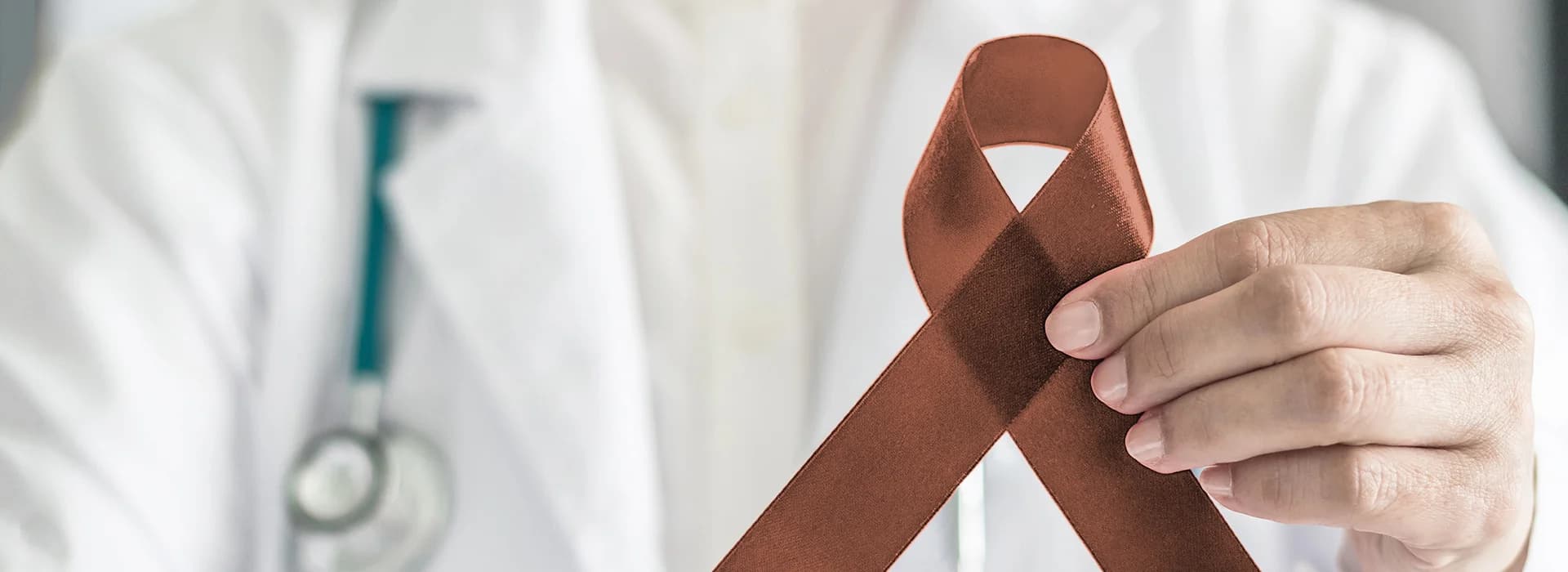 Photo medical professional holding ribbon representing oral cancer screening in Astoria NY
