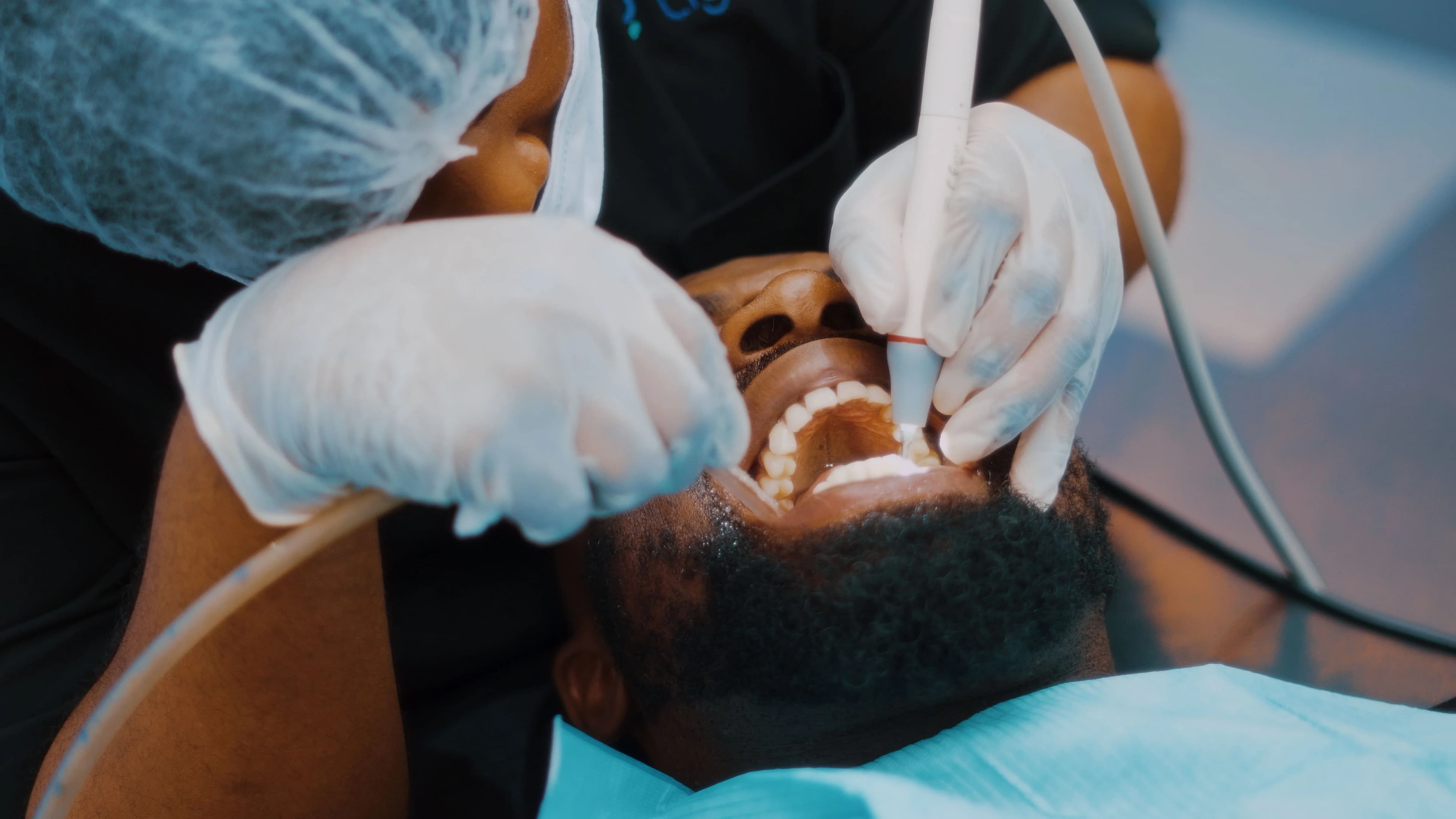Photo patient receiving teeth cleaning in Astoria with dental instruments inside mouth