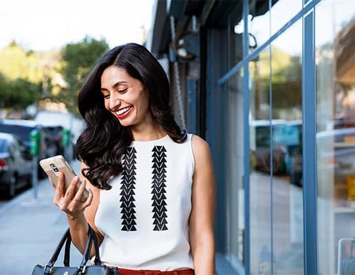 Photo woman smiling at phone outside dentist Ditmars Astoria office