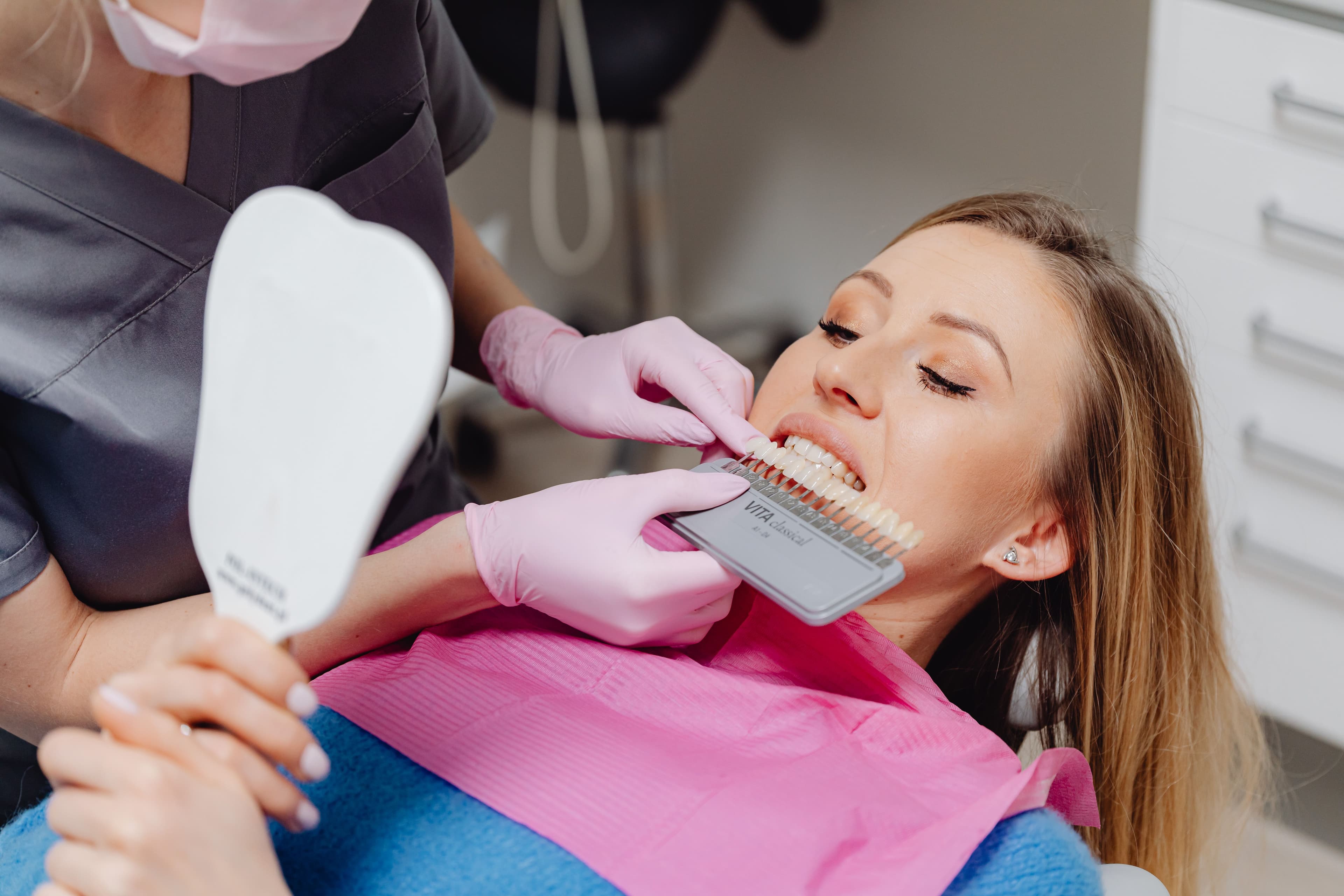 Photo Patient Comparing Teeth Shades Porcelain Vs Composite Veneers Mirror Exam