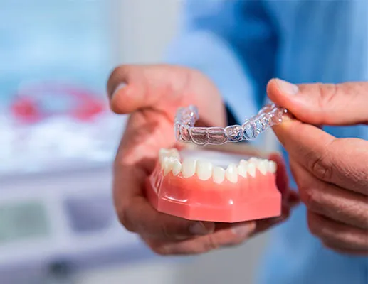 Hands Holding Dental Model With Teeth And Clear Aligner Above Demonstrating Invisalign Process Step By Step For Patient Education In Dental Office