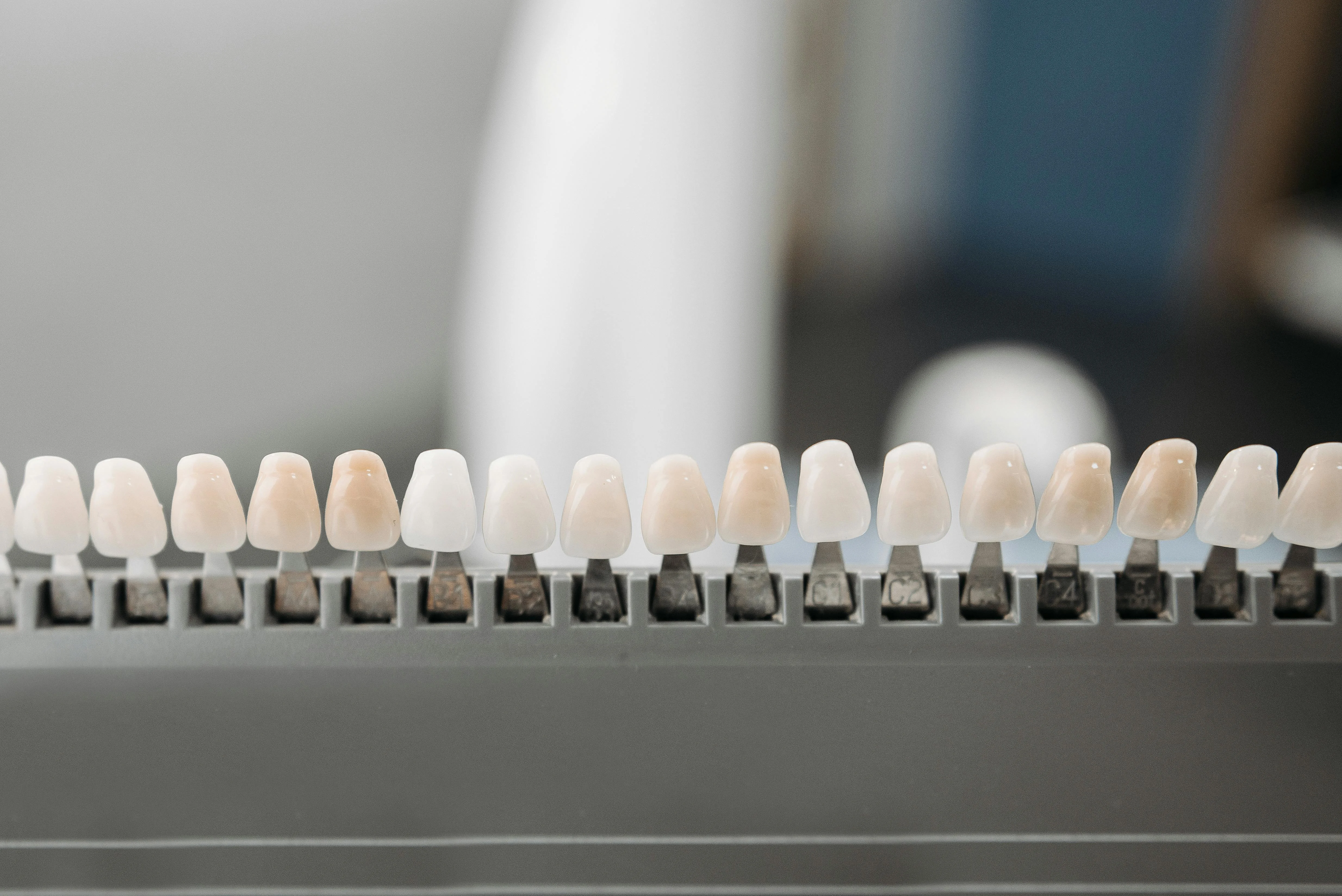 Multiple tooth shade samples displayed on dental tray for color selection during composite veneers vs porcelain veneers treatment comparison.